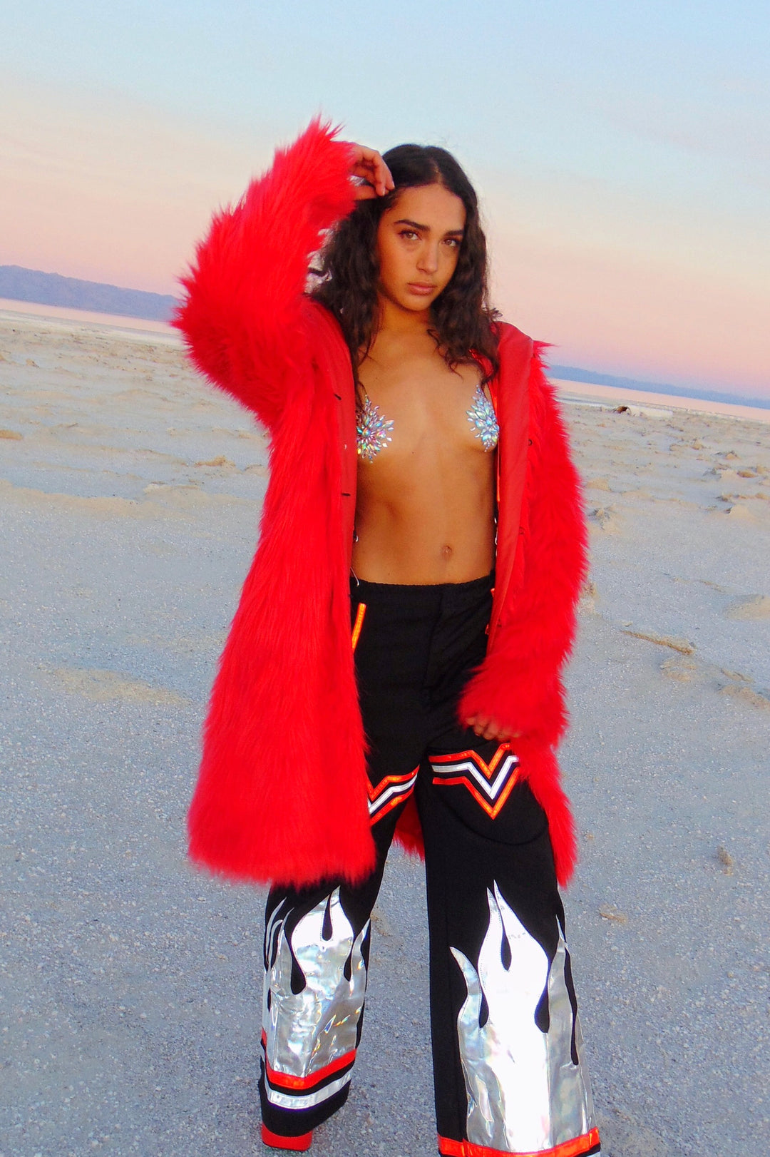 Bright red, long haired faux fur coat with hood by Space island. Spvce Island is a wearable art collective featuring festival fashion, rave wear, club wear and streetwear. Buy coats, jackets, platform boots, gogo boots, rainbow platform sneakers, holographic sandals, shoes, burning man goggles, crystal chokers, holographic corsets, joggers, rave bottoms, bikinis, harnesses, bondage and more. 